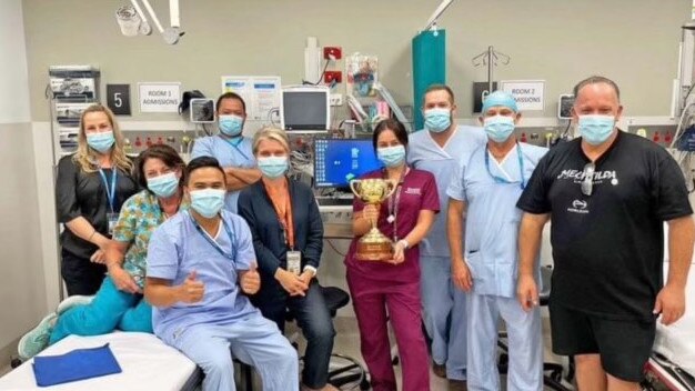 Jason Woodbridge brought the winning Melbourne Cup trophy to the doctors and nurses who saved his life at the Gold Coast University Hospital. Pictures: Supplied.