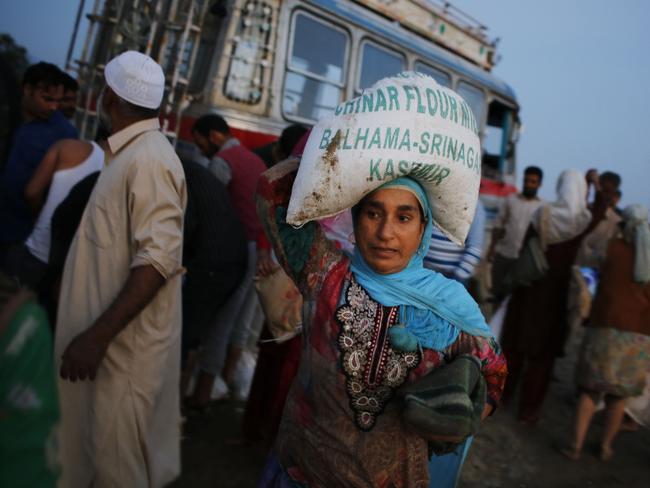 A Kashmiri flood victim carries a sack containing relief material in Teing, near Srinagar.