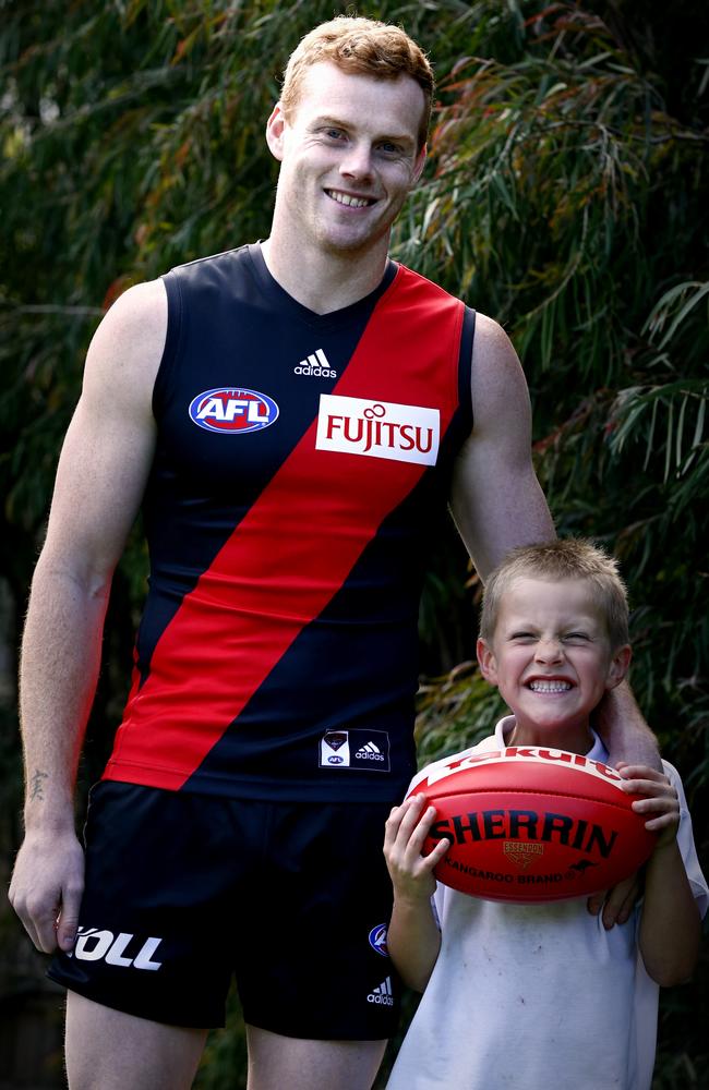 Adam Cooney with his son, Jax, 6, in the backyard. Picture: Wayne Ludbey