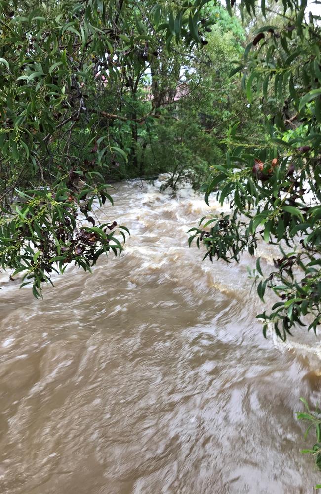 Water rushes through an open drain between Estia Health Mount Coolum Residential Aged Care this morning