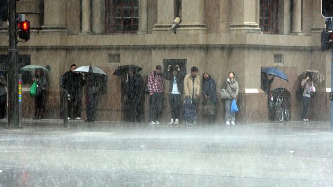 Heavy rainfall in Adelaide. People try to shelter from rain on Waymouth Street.