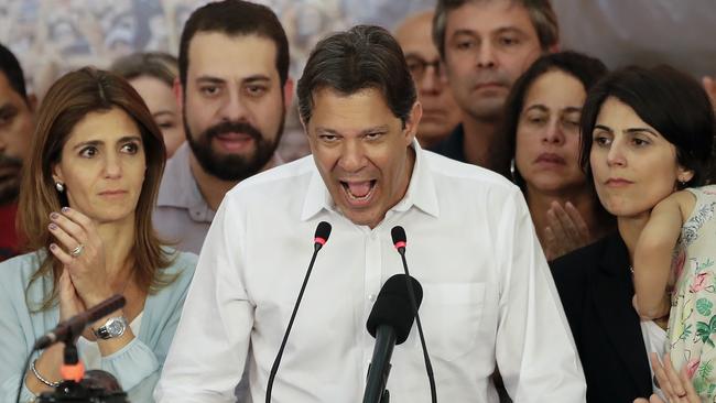 Flanked by his wife Ana Estela, left, and running mate Manuela d'Avila, Fernando Haddad concedes in Sao Paulo, Brazil. Picture: AP