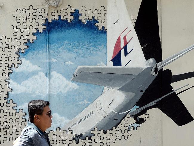 A man walks past a mural of missing Malaysia Airlines MH370 plane in Shah Alam. Picture: AFP