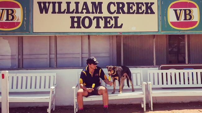 Maz Salvati and dog Lewis taking a break from work with some ice blocks in front of the William Creek hotel, where it was 46C at 1pm. Picture: Rose Broughton