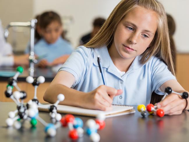 CAREERS: Preteen girl using atom educational toy in science class