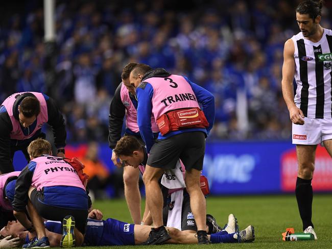 Brodie Grundy looks over a prone Ben Brown.