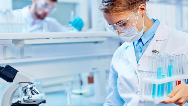 HEALTH:  Young woman with flasks making notes in laboratory. Biotechnology research  laboratory generic