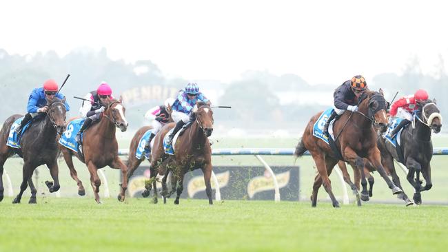 Flattered (blue jacket, red cap) charged into second behind impressive winner Heinous (black and orange). Picture: Scott Barbour/Racing Photos via Getty Images