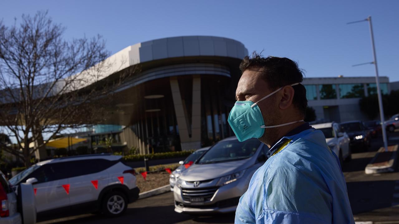 A medical worker is seen at a drive-through COVID-19 testing clinic. Sydney’s cases grew by 65 on Thursday, but non-essential businesses remain open. Picture: Brook Mitchell/Getty Images