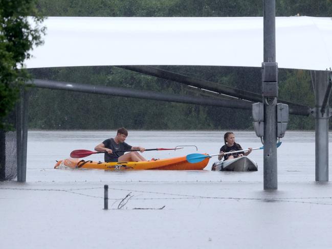 People kayaking down what would be Oxley Rd, Oxley, on Monday. The suburb had multiple streets under water. Picture: Steve Pohlner