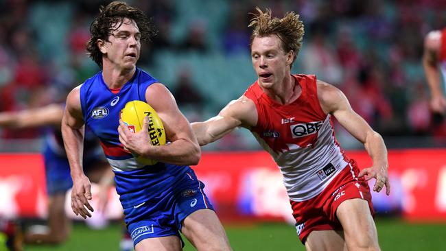 Liam Picken tries to slip out of a tackle by Callum Mills.