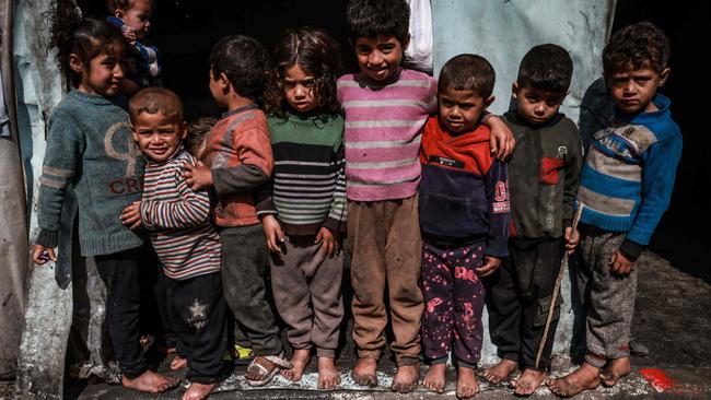 Displaced Palestinian children in front of makeshift tents at a camp beside a street in Rafah. Picture: AFP