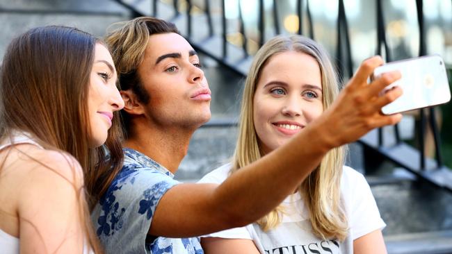 Peri Crawford, 20, and Kate McCabe, 20, take a picture with Coleman at Pacific Fair. Picture: Adam Head