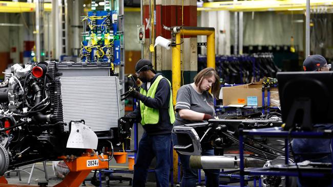 Line workers work on the chassis of full-size General Motors pick-up trucks at the Flint Assembly plant in Flint, Michigan. GM has announced that it "aspires" to eliminate emissions-producing vehicles from its light-duty fleet by 2035. Picture: Jeff Kowalsky.