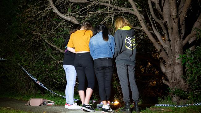 Young mourners pay their respects and lay flowers at the scene of the tragic shooting.