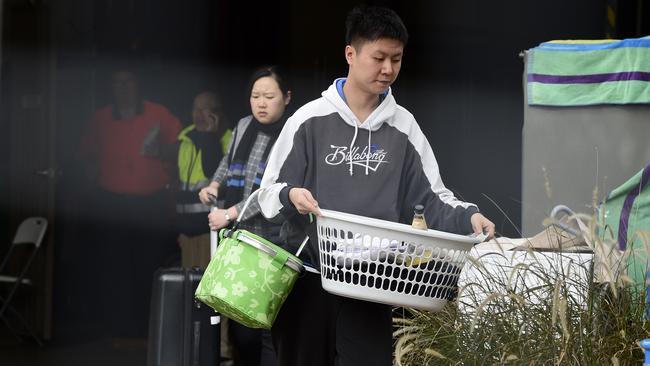 Residents seen carrying their personal items out of the Mascot Towers in June. Picture: Bianca De Marchi