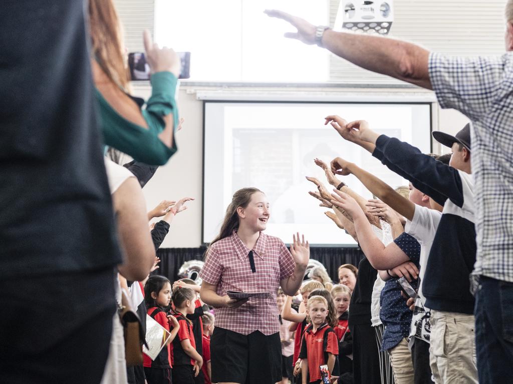 Sacred Heart Primary School Year 6 student Michaela King leaves the awards presentation and Yr 6 graduation under the arch of honour formed by attendees, Friday, December 2, 2022. Picture: Kevin Farmer