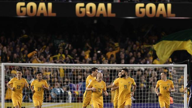 Socceroos players run back after Mile Jedinak’s goal.