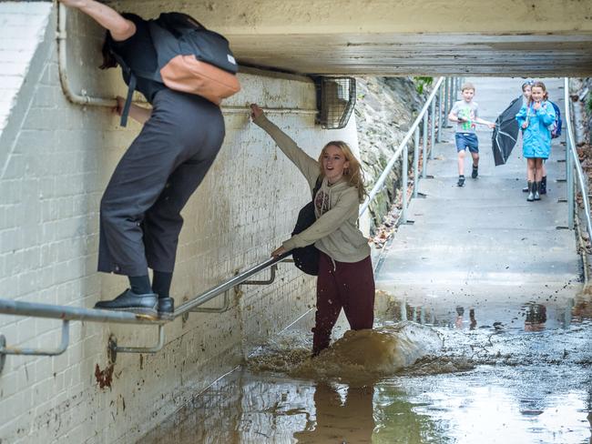 Commuters navigate a flooded underpass at Northcote train station. Picture: Jake Nowakowski