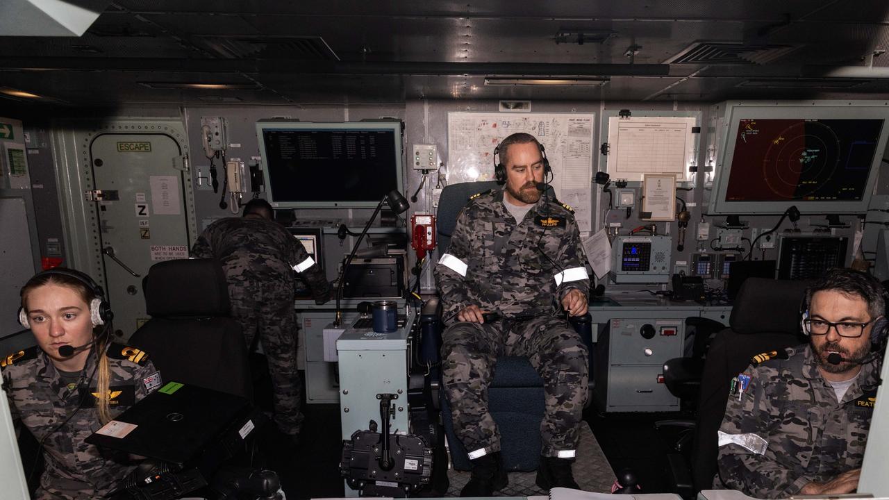 Commanding Officer HMAS Warramunga Commander Dylan Phillips CSM observes the ships actions in operations room with Lieutenant Amy Steele controlling air operations to the left and Lieutenant Matt Featherstone monitoring the tactical space to the right. Picture: Department of Defence.