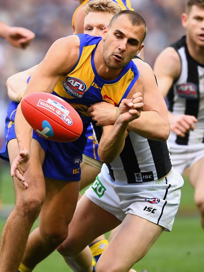 Dom Sheed is tackled by Adam Treloar.