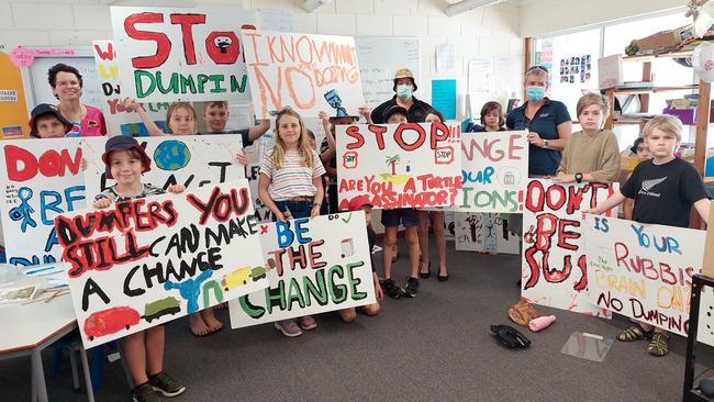 Enkindle Village School students show off their hand painted signs that will feature at rubbish dumping sites. Picture: Leighton Smith