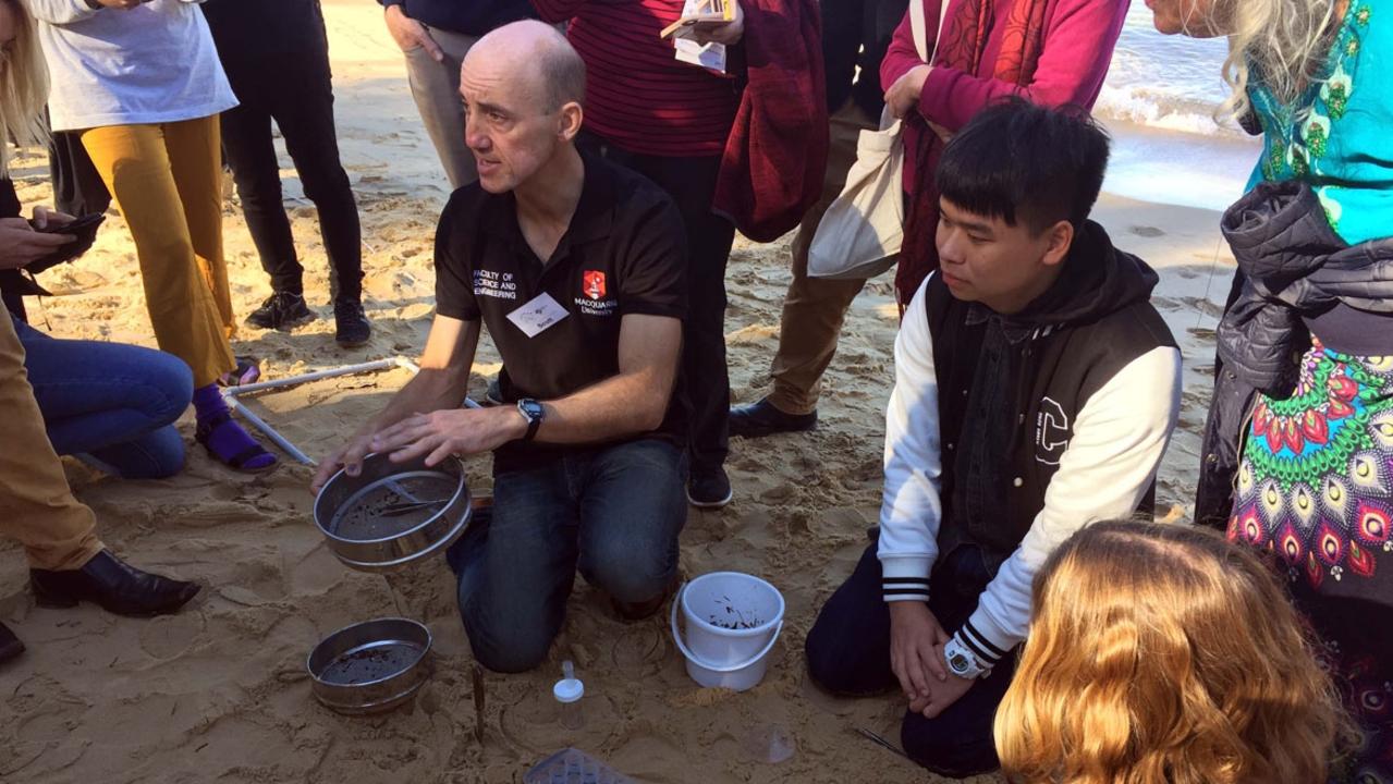 Dr Scott Wilson, research director for the Australian Microplastic Assessment Project (AUSMAP) showing volunteers how to search for microplastics in Manly Cove. Picture: AUSMAP