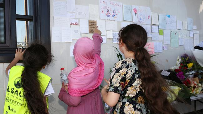 Girls read messages of support at the Marion vivil. Picture: AAP / Emma Brasier