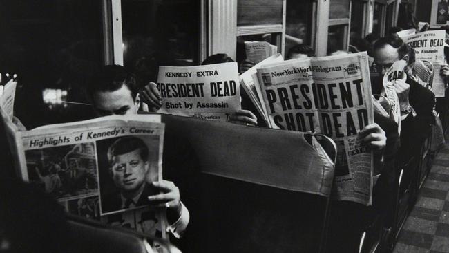 Commuters read of John F Kennedy's assassination in 1963. Picture: Carl Mydans