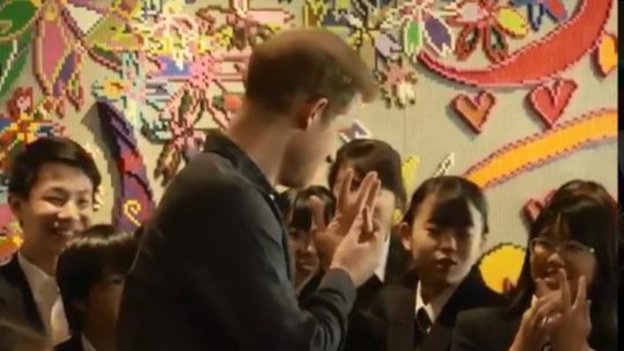 Prince Harry flashes his wedding ring to Japanese schoolgirls. Picture: Supplied