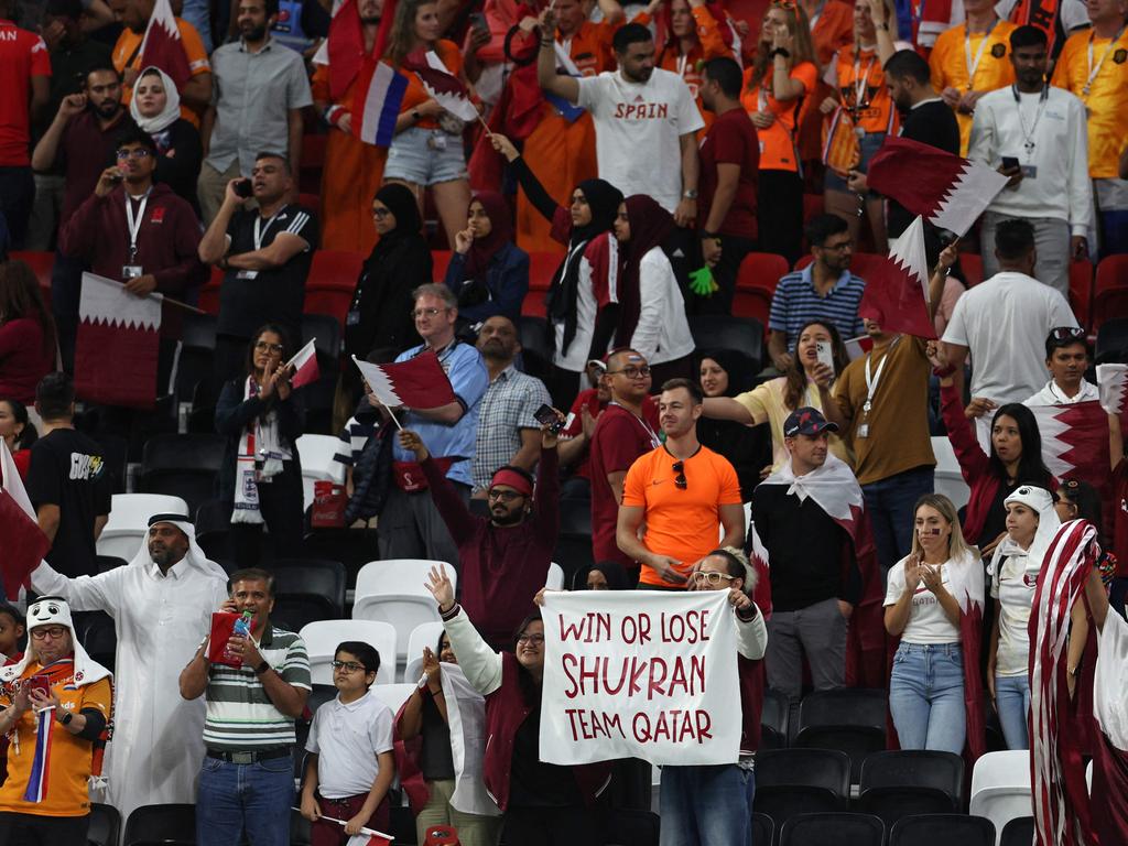 A supporter holds a banner reading "Win or lose, Shukran (Thank you) team Qatar". Picture: Adrian Dennis/AFP