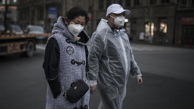 Wuhan residents wear face masks as they walk the city’s streets. Picture: Getty Images