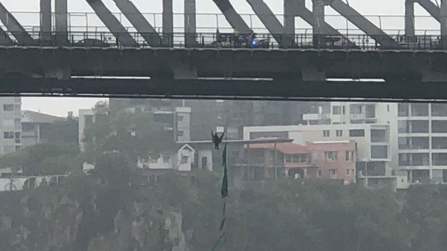 A man is hanging from the underside of the Story Bridge. Picture: Dr Stephen Rashford/Twitter