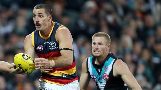 Clurey in hot pursuit of Taylor Walker in the Showdown. Picture: Sarah Reed/AFL Photos