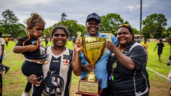 2024 Indigenous Round Honouree Mary Dunn presenting the Mary Dunn Cup to the 2023 Tiwi Islands Football League women's premiers Muluwurri Magpies (December 2023). Picture: Patch Clapp / AFLNT Media