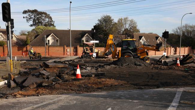 Crews work to remove debris and fix the intersection at Fullarton Rd and Carrick Hill Dr after the burst water main. Picture: Emma Brasier