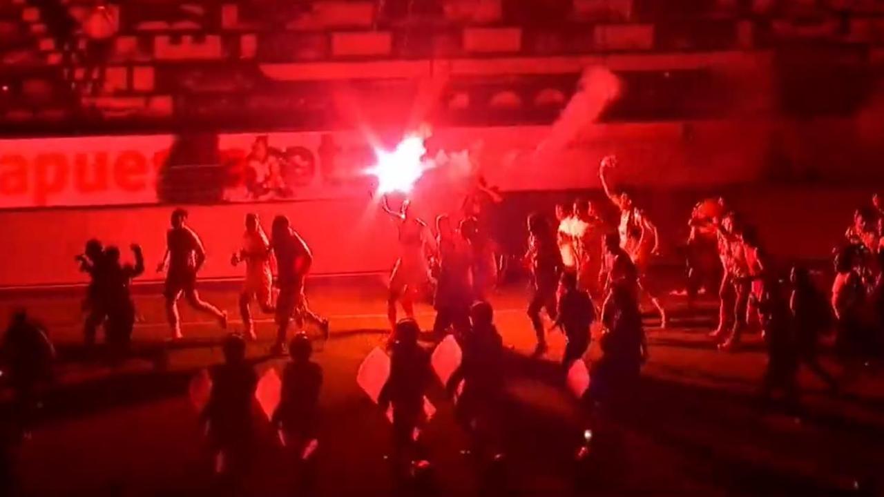 Universitario players carried a flare around the stadium as they celebrated in the dark.