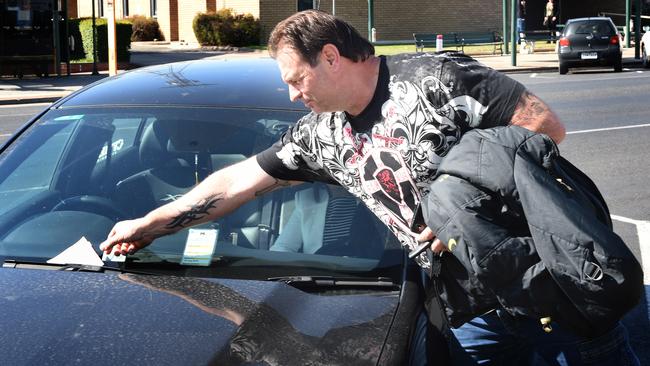 Mr Setka collecting the parking fine off his windshield. Picture: Tony Gough