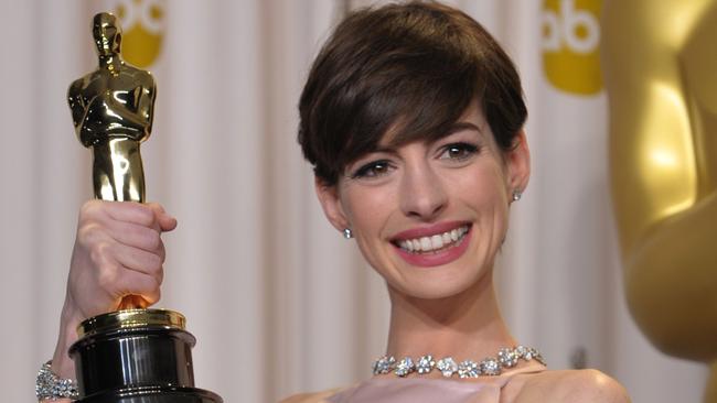 Anne Hathaway poses with her award for best actress in a supporting role for 