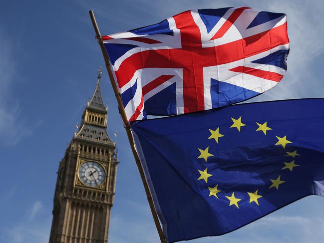 (FILES) In this file photo taken on March 25, 2017 An EU flag and a Union flag held by a demonstrator is seen with Elizabeth Tower (Big Ben) and the Houses of Parliament as marchers taking part in an anti-Brexit, pro-European Union (EU) enter Parliament Square in central London on March 25, 2017, ahead of the British government's planned triggering of Article 50 next week. - British and European Union negotiators have reached a draft agreement on Brexit, Prime Minister Theresa May's office said on November 13, 2018. (Photo by Daniel LEAL-OLIVAS / AFP)