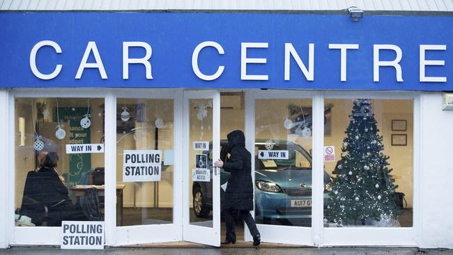 A Christmas tree stands in the window of Petersfield Used Car Centre in Hampshire, which is being used as a polling station in the British general election. Picture: AP