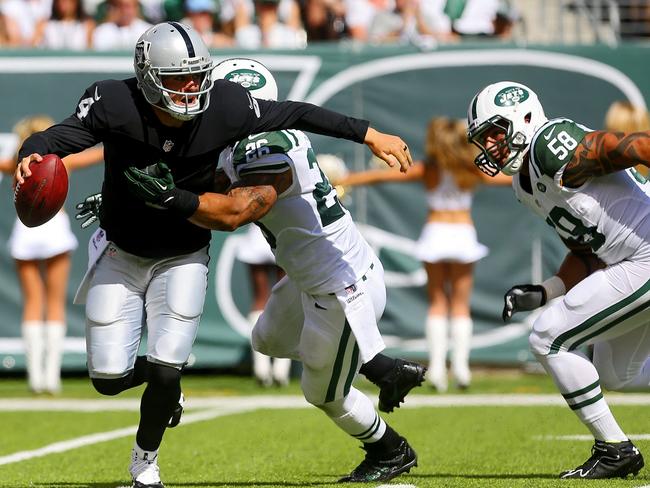 Dawan Landry #26 and Jason Babin #58 of the New York Jets sack Derek Carr #4 of the Oakland Raiders.