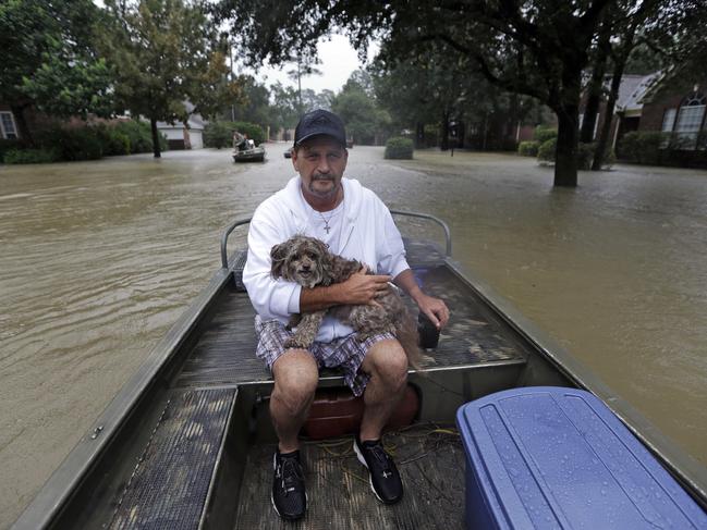 Lance Cross holds his dog Max while being evacuated from his home as floodwaters from Tropical Storm Harvey rise Monday, Aug. 28, 2017, in Spring, Texas. Picture: AP