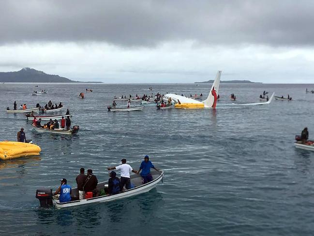 This picture taken by James Yaingeluo on September 28, 2018 shows locals approaching to rescue passengers of the crashed Air Niugini aircraft on the remote Island of Weno, in Micronesia. - An Air Niugini aircraft ditched into a lagoon after overshooting the runway on the remote island of Weno but there were no serious injuries, local media reports said. (Photo by James YAINGELUO / AFP) / -----EDITORS NOTE --- RESTRICTED TO EDITORIAL USE - MANDATORY CREDIT "AFP PHOTO / JAMES YAINGELUO" - NO MARKETING - NO ADVERTISING CAMPAIGNS - DISTRIBUTED AS A SERVICE TO CLIENTS - NO ARCHIVE