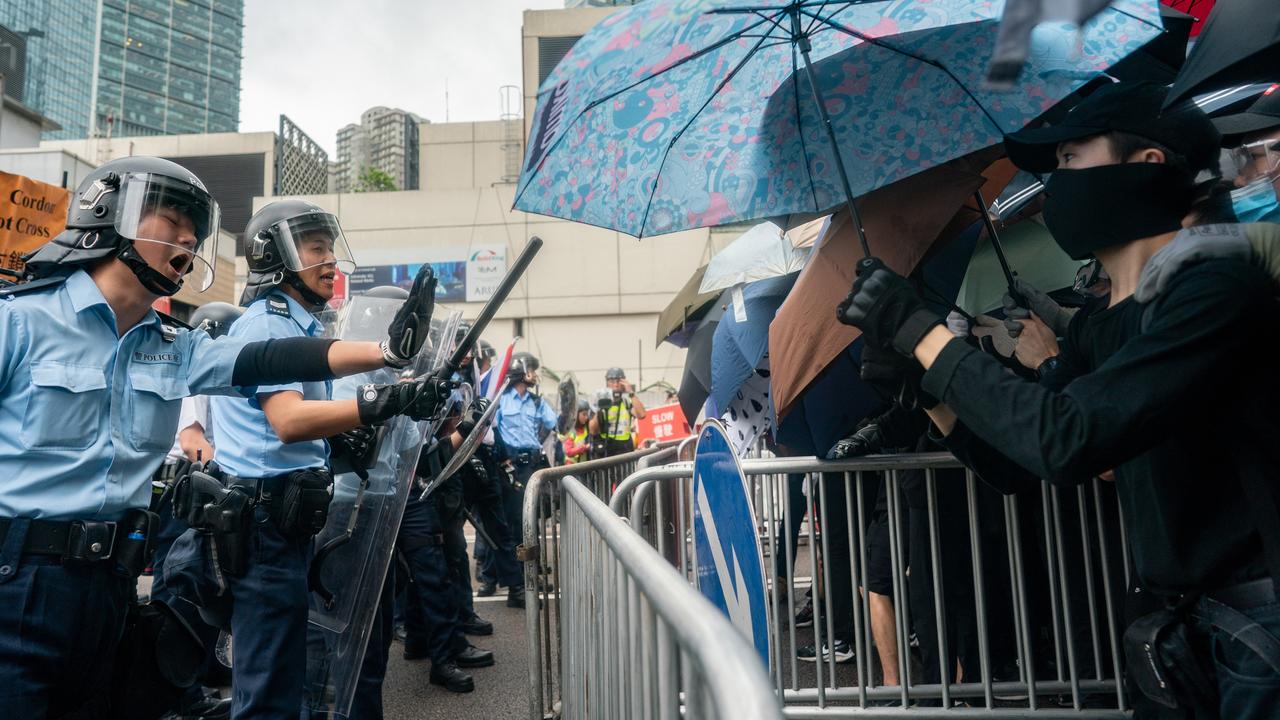 Police officers stand guard as protesters block a street near the government headquarters. Picture: Anthony Kwan/Getty Images