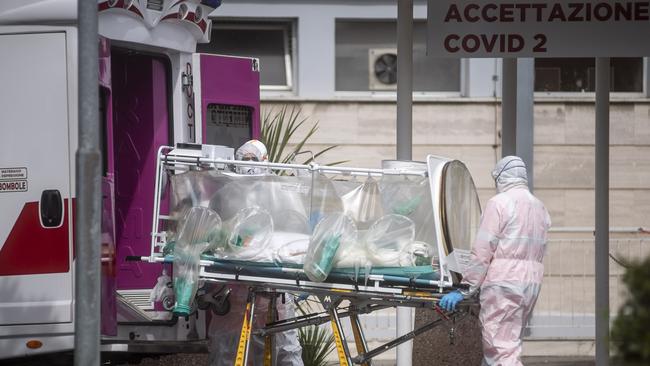 Medical staff collect a patient from an ambulance at the second Covid-19 hospital in the Columbus unit in Rome,.