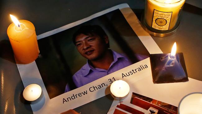 SYDNEY, AUSTRALIA - APRIL 28: A woman places a candle on top of a picture of Australian Andrew Chan, one of one of the prisoners to be executed in Indonesia, during a vigil at Martin Place on April 28, 2015 in Sydney, Australia. Supporters of Bali Nine duo Andrew Chan and Myuran Sukumaran held a vigil tonight as the pair prepare to face the firing squad this evening at Indonesia's Nusakambangan Island. Chan and Sukumaran were both sentenced to death after being found guilty of attempting to smuggle 8.3kg of heroin valued at around $4 million from Indonesia to Australia along with 7 other accomplices. (Photo by Daniel Munoz/Getty Images)