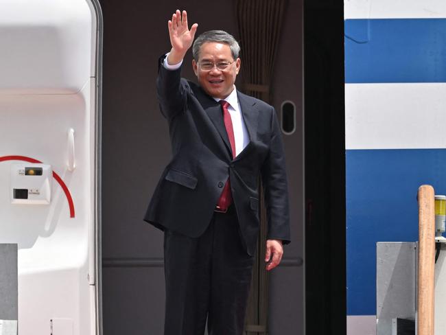 Chinese Premier Li Qiang (C) waves as he boards his plane prior to departure from Seoul Air Base in Seongnam on May 27, 2024, after the trilateral summit with South Korean President Yoon Suk Yeol and Japanese Prime Minister Fumio Kishida. (Photo by Jung Yeon-je / AFP)