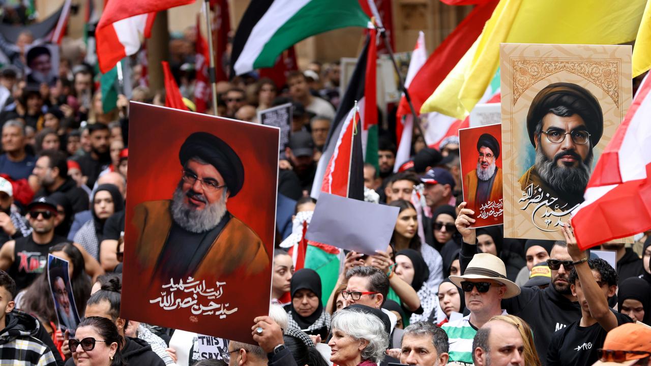 People hold up pictures of Hezbollah leader Hassan Nasrallah at a protest at Town Hall in Sydney last Sunday. Picture: NewsWire / Damian Shaw