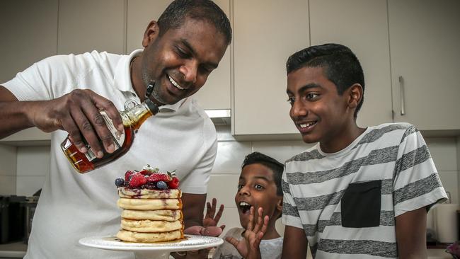 Sashi Cheliah in the kitchen at home with his children Ryan, 10, and Marcus, 12. Picture: AAP / Mike Burton